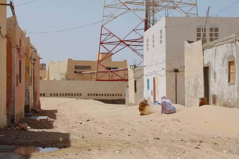 Western Sahara is a peculiar country. The towns seems deserted and full of sand, yet there is a certain mystique in the air... Notice this woman shovelling sand away from her front door. The wind brings the desert dunes right into people's homes...